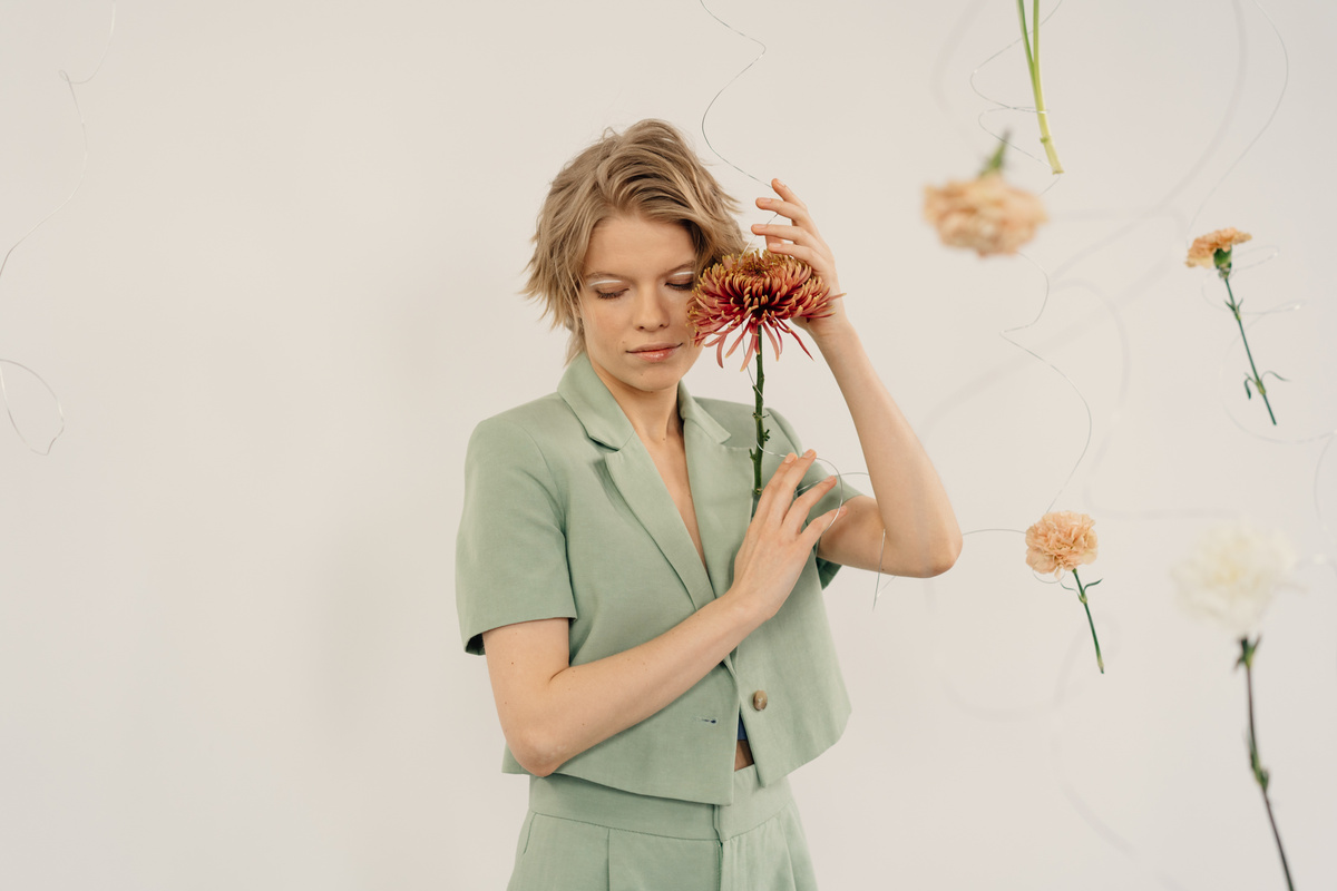 Woman in Green Blazer Posing with a Flower